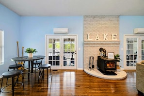 A room with a fireplace, a dining area with a table and chairs, and a door labeled 'LAKE'.