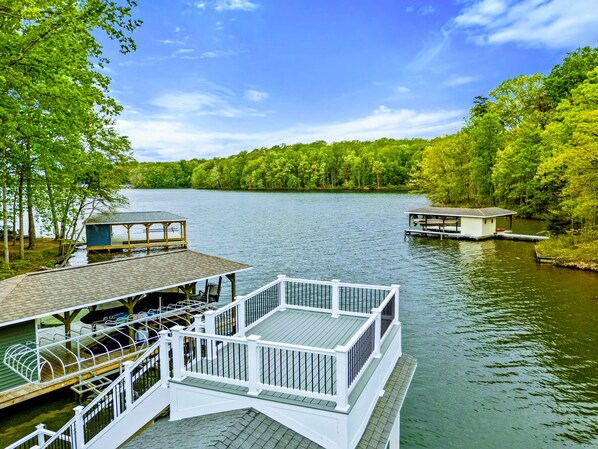 A lakeside dock with a covered seating area and a small building, surrounded by dense greenery. - Lakefront Retreat, Pool, Boat Dock, Hot Tub (Bumpass)
