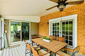 A covered patio with a wooden table and chairs, a ceiling fan, and a brick wall. - Lakefront Retreat, Pool, Boat Dock, Hot Tub (Bumpass)