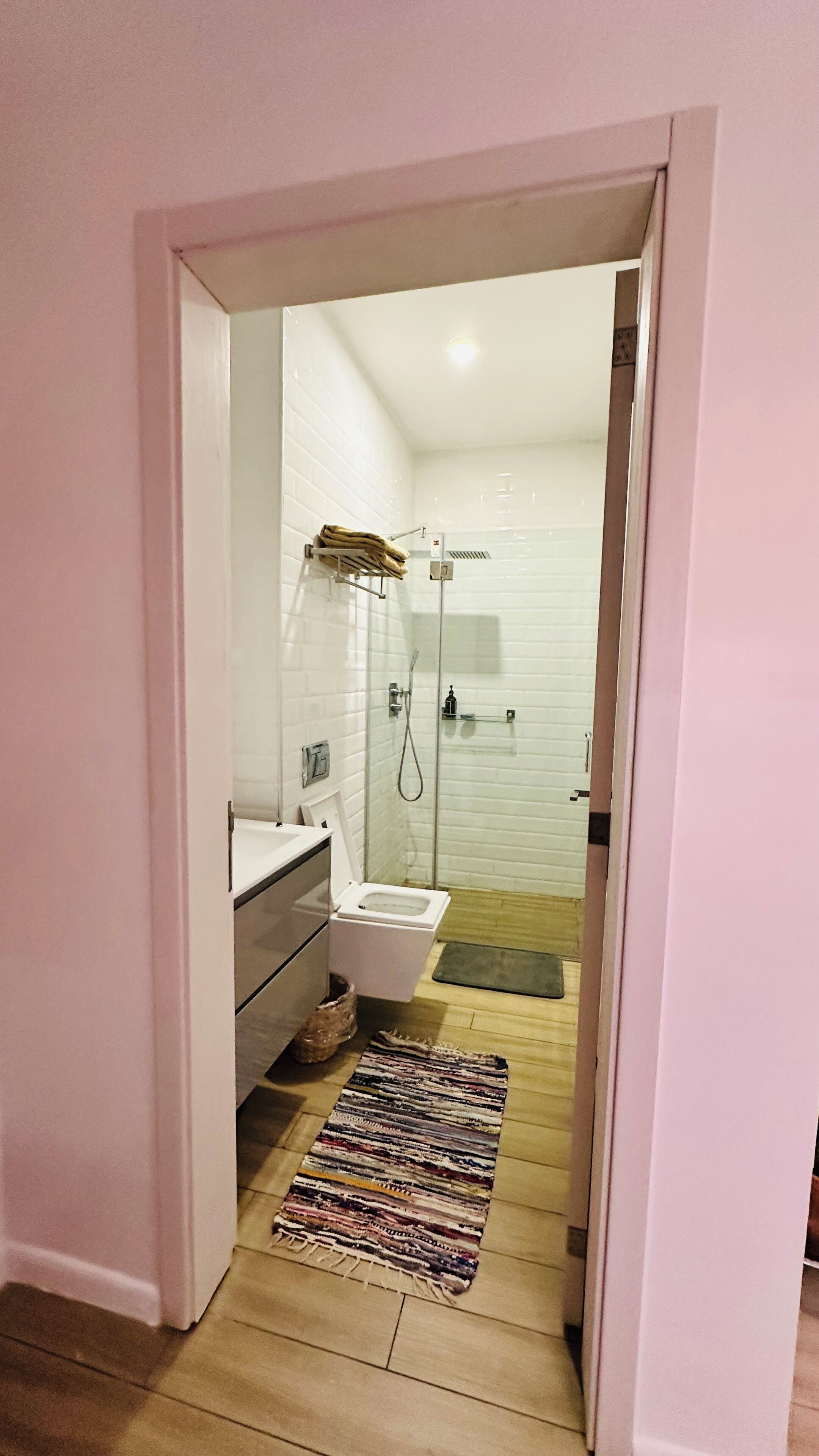 A bathroom with a shower, toilet, and sink.
