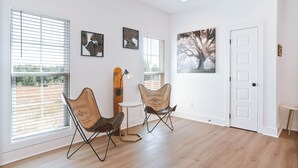 A room with two folding chairs, a small table, and a large window with blinds. - Charming 2-bedroom townhome with WiFi and AC in Auburn (Auburn)