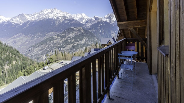 A wooden balcony with a view of snow-capped mountains. - Apartment in Modane Near Ski Slopes (Modane)