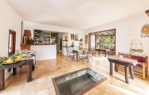 Une cuisine spacieuse avec un coin repas, un bar et une vue sur le jardin.
