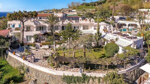 A coastal residential area with modern houses, a swimming pool, and a stone pathway. - Ravino Ecolodge (Forio)