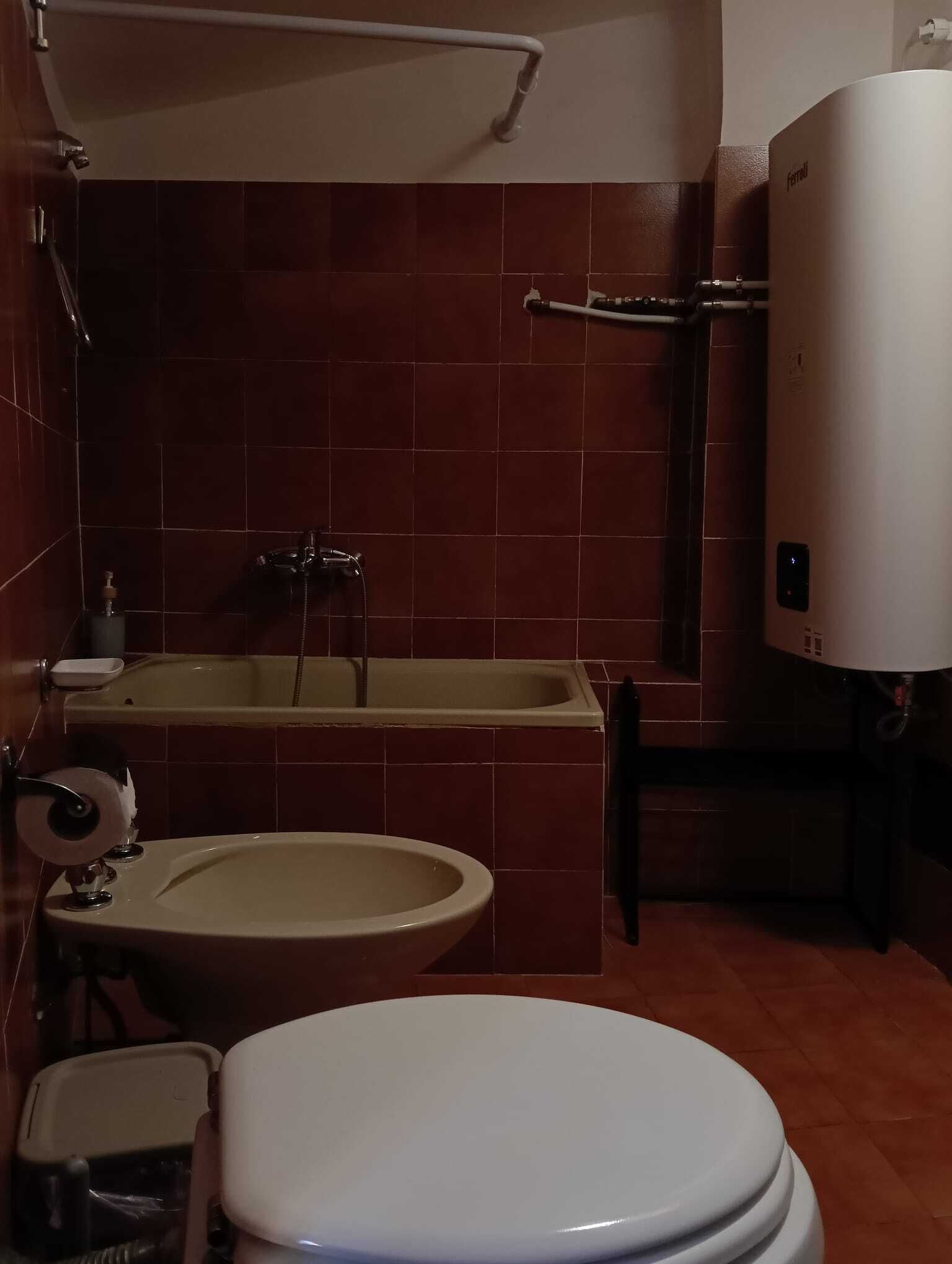 A bathroom with a toilet, bidet, and bathtub.