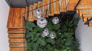 A wooden staircase with glass railings and hanging spherical light fixtures. - Casa Noral Hotel (Copacabana)