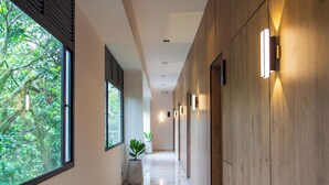 A modern hallway with wooden paneling, large windows, and potted plants. - Casa Noral Hotel (Copacabana)