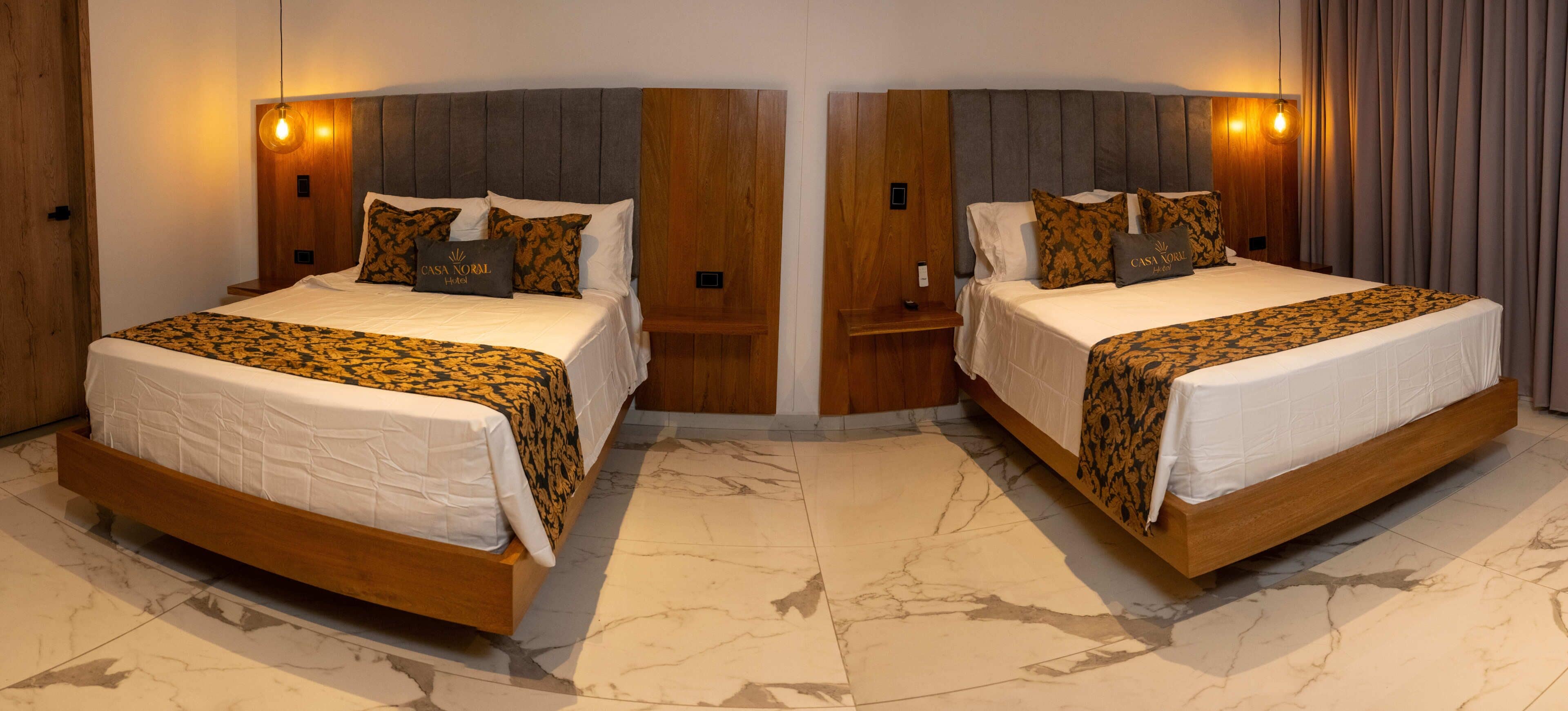 A mirrored room with two identical beds, wooden headboards, and marble flooring.