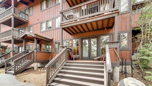 A multi-story building with wooden exterior, a staircase leading to a deck, and outdoor seating. - Hike, Sled & Ski! Cozy Tahoe City Condo w/ Hot Tub (Tahoe City)