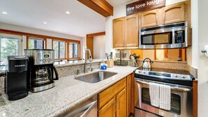 A kitchen with granite countertops, stainless steel appliances, wooden cabinets, and a sign that says "live love laugh". - Hike, Sled & Ski! Cozy Tahoe City Condo w/ Hot Tub (Tahoe City)