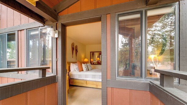 A wooden cabin with a bedroom featuring a bed, pillows, and a nightstand. - Hike, Sled & Ski! Cozy Tahoe City Condo w/ Hot Tub (Tahoe City)