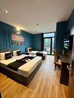 Una habitación de hotel con una cama grande, un escritorio, una silla y un televisor.