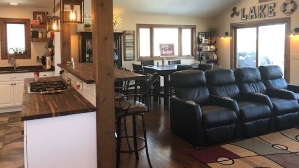 Amplia sala de estar con chimenea, mesa de comedor y zona de estar con sofás de cuero.