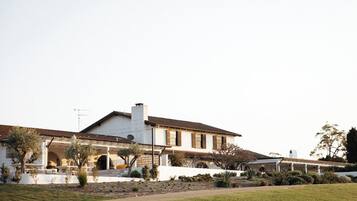 A large, single-story house with a patio area and a covered outdoor seating space.