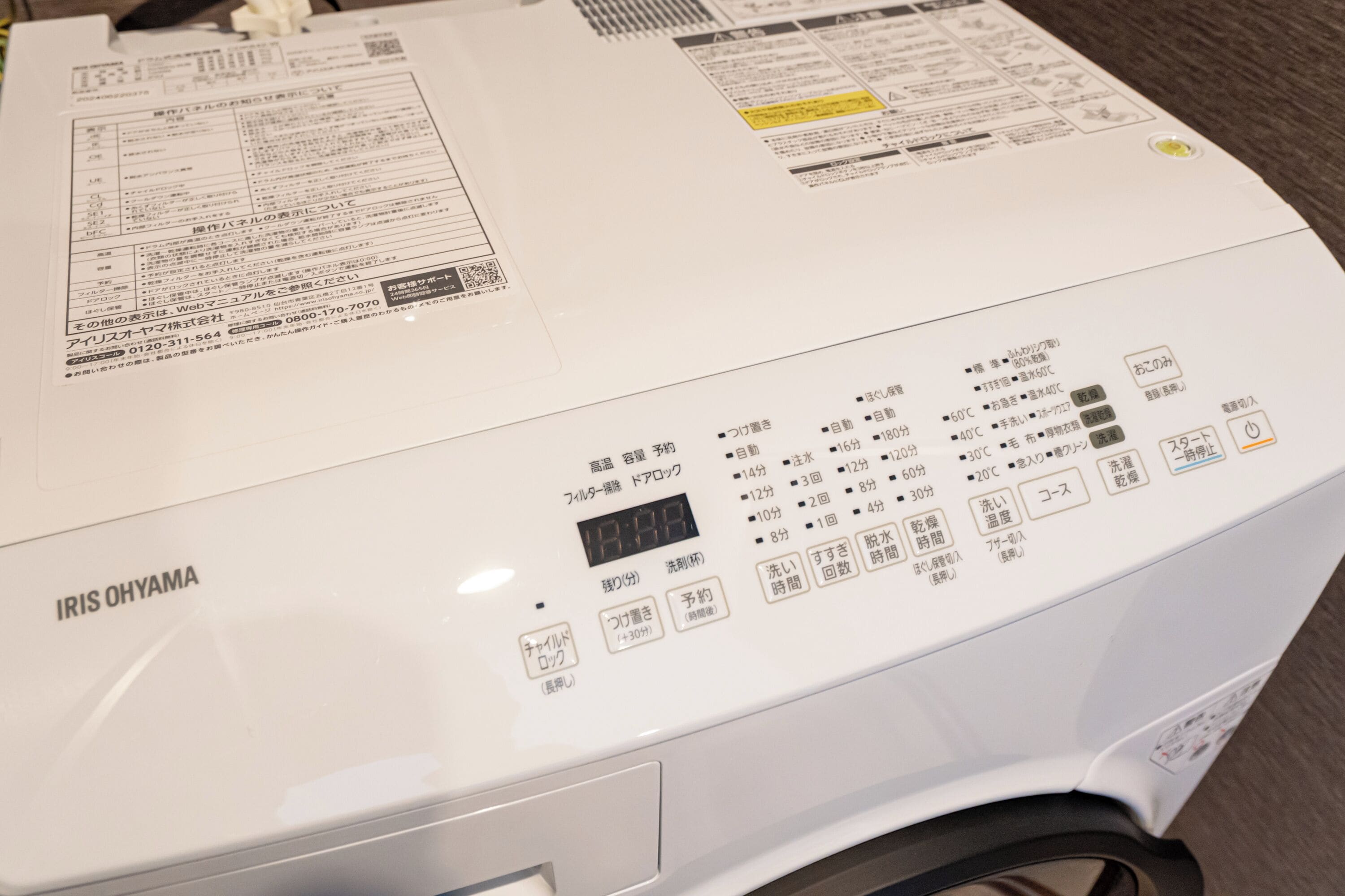 A white washing machine with Japanese instructions and a digital display.