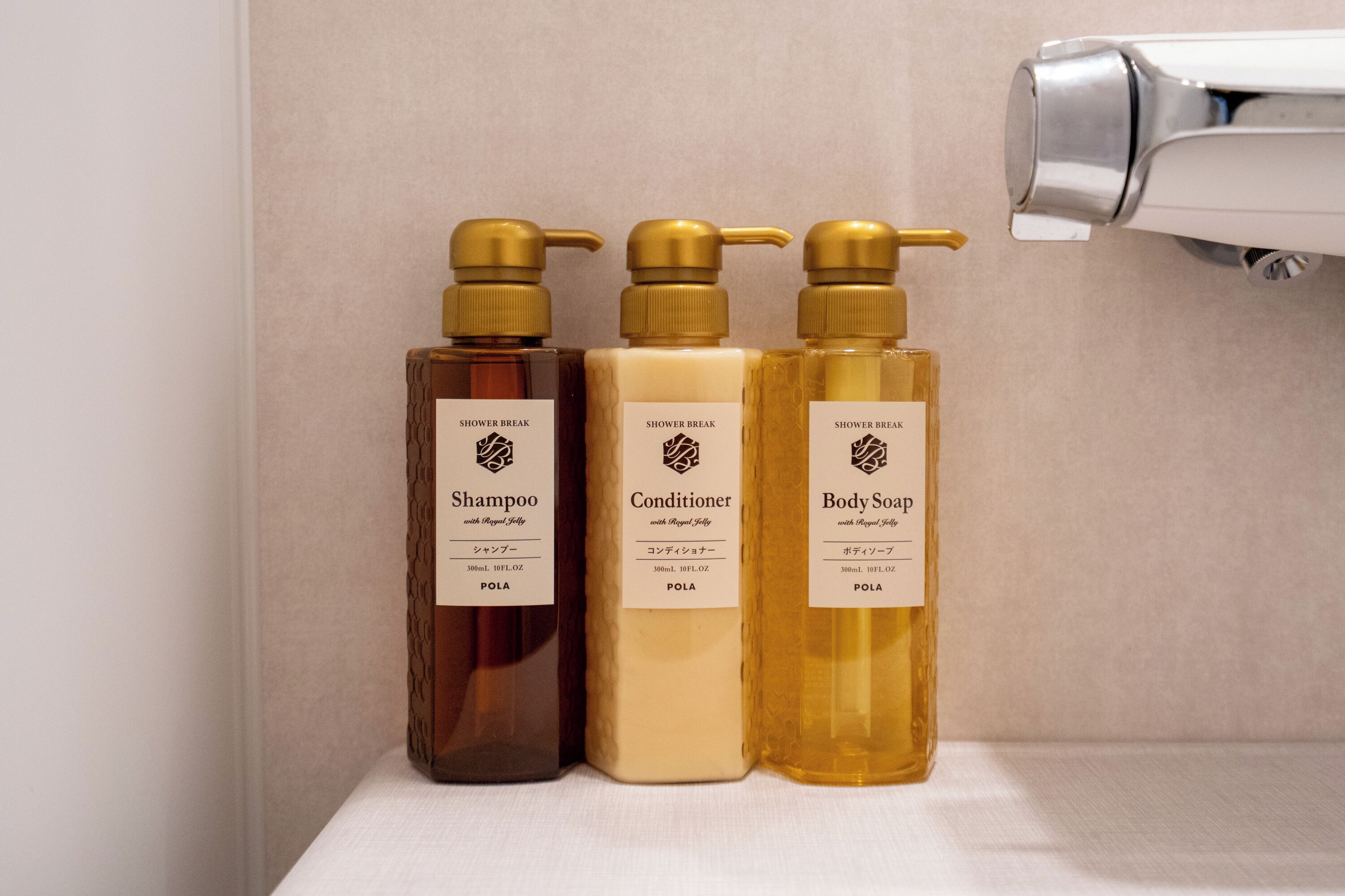 Three bottles of shower break products on a shelf.