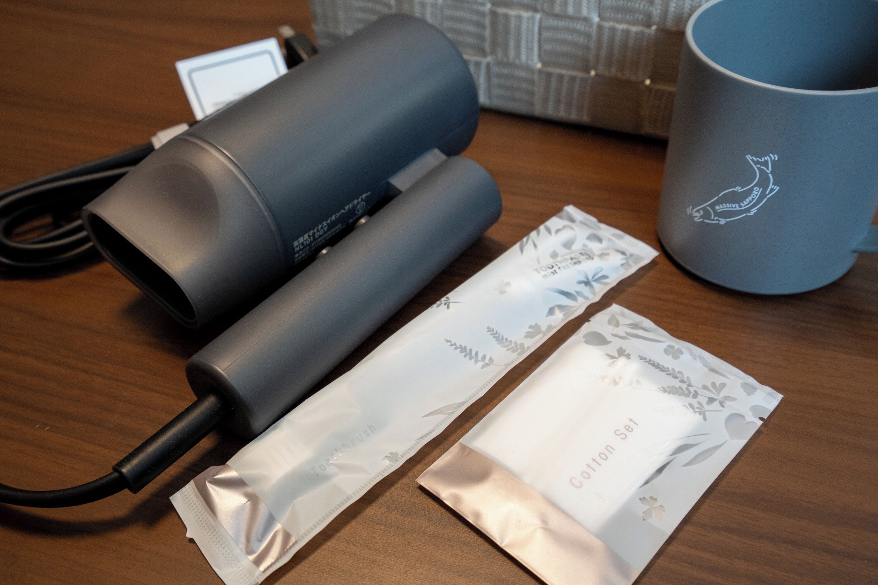 A table with a cylindrical device, a mug, and two packets labeled "Cotton Set."
