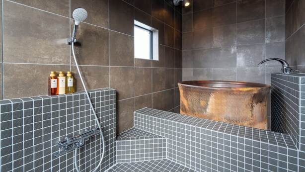 Un baño moderno con una bañera grande, un cabezal de ducha y una ventana.