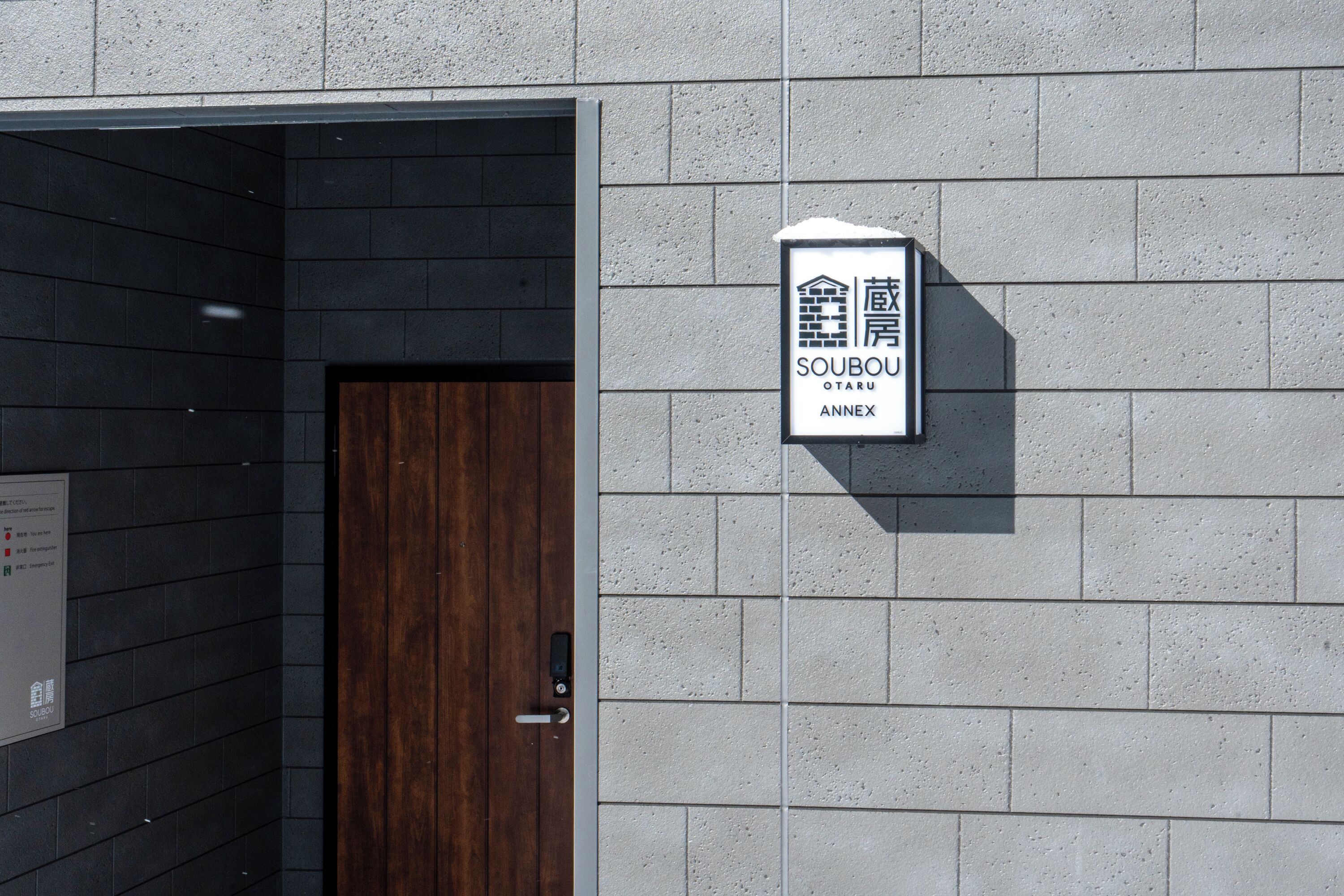 A sign for "Soubou OTARU ANNEX" on a building wall.