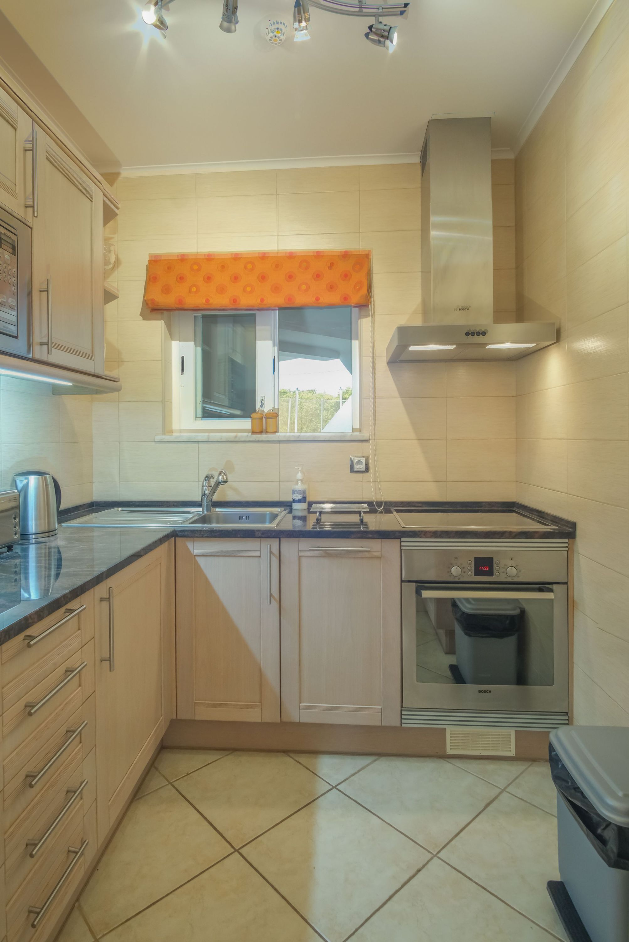 A kitchen with a sink, stove, oven, and cabinets.