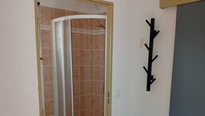 A room with a shower area, a wooden floor, and a quilt on the bed. - Apartment at the foot of the slopes, near outdoor swimming pool (summer) with garage. (Saint-François-Longchamp)