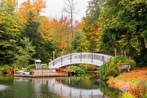 A white bridge over a calm river, surrounded by autumn foliage. - Nordic Village | Sunrise Townhouse – 2BR End Unit w/ Mountain Views (Jackson)