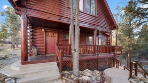 A log cabin with a porch, steps, and a wooden railing. - Indulge in the Perfect Family Adventure (Sugarloaf)