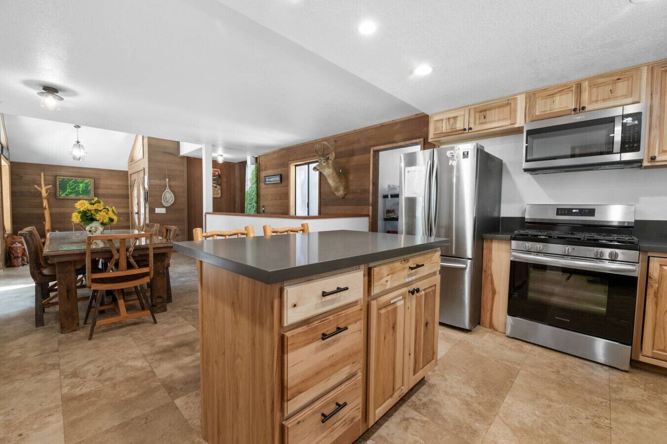 Una cocina moderna con armarios de madera, electrodomésticos de acero inoxidable y una isla central.
