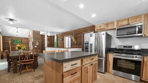 A modern kitchen with wooden cabinets, stainless steel appliances, and a central island. - The Circle Moon - 1 mi to Bear Mtn/ Game Room+Spa! (Big Bear Lake)