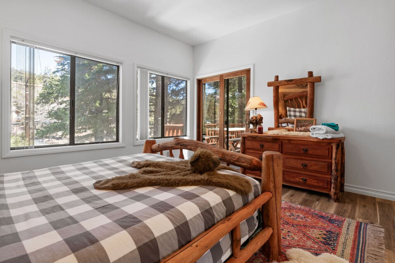 Un dormitorio con una cama grande, cabecera de madera, un aparador y un espejo.