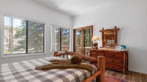 A bedroom with a large bed, wooden headboard, a dresser, and a mirror. - The Circle Moon - 1 mi to Bear Mtn/ Game Room+Spa! (Big Bear Lake)