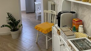 A kitchen with a white refrigerator, a coffee machine, and a shelf with coffee cups. - Goti Rooms B&B (Sant'Agata de'Goti)
