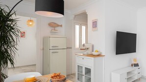 A modern kitchen with a refrigerator, a sink, and a dining area with a table set for two. - Centric but quiet. Terrace with views to the sea (Nerja)