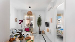 Una sala moderna con comedor, una planta grande en maceta y vistas al exterior.