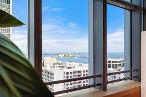 A view from a window with a metal frame, overlooking a body of water and buildings. - Brickell Arch City Views Pool & Free Parking (Miami)