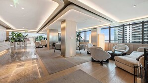 A spacious lobby with a modern design, featuring a reception desk, seating area, and large windows offering views of the city. - Brickell Arch City Views Pool & Free Parking (Miami)
