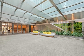 A spacious lobby with a high ceiling, a staircase, and seating areas.