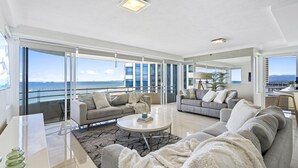 A spacious living area with large windows, a balcony, and a view of the ocean. - Spacious 2 Bedroom Ocean View Apartment - Q Stay (Surfers Paradise)