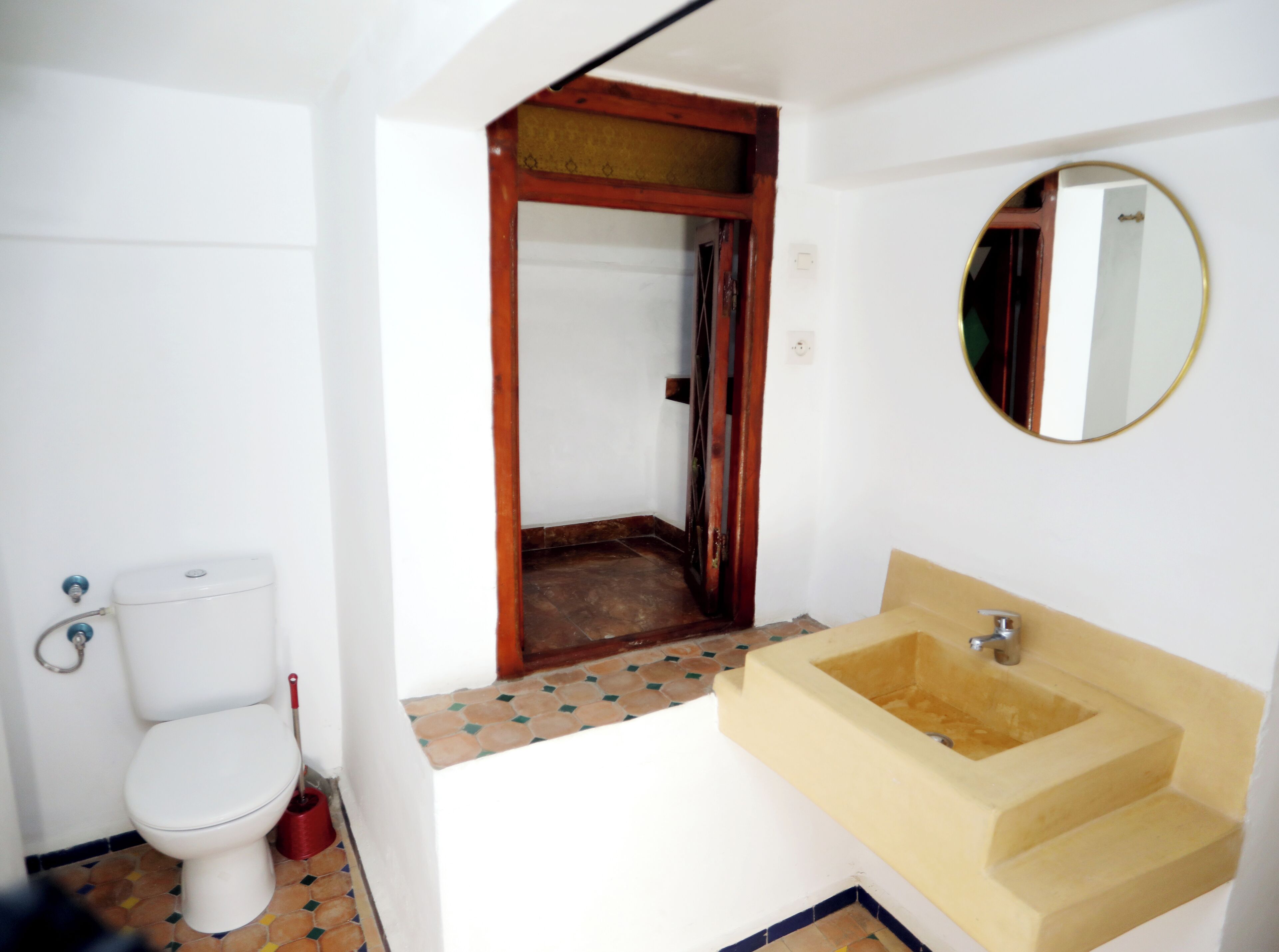 Un baño con inodoro, lavabo y espejo.