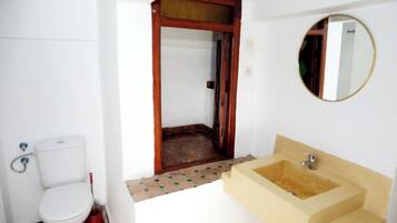 Un baño con inodoro, lavabo y espejo.