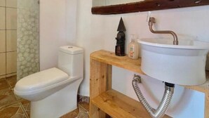 A bathroom with a toilet, a sink, and a shower. - JUMANJI  (Palomino)