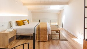 Ein Schlafzimmer mit einem Bett, einem Nachttisch und einem Lesesessel.