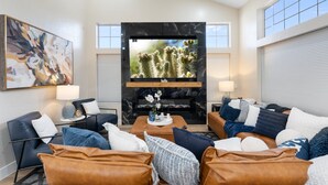 A modern living room with a fireplace, comfortable seating, and artwork on the walls. - 8BR/5BA Mini Resort w/4 En-Suites, HEATED Pool, Hot Tub,Billiards & Arcades (Glendale)