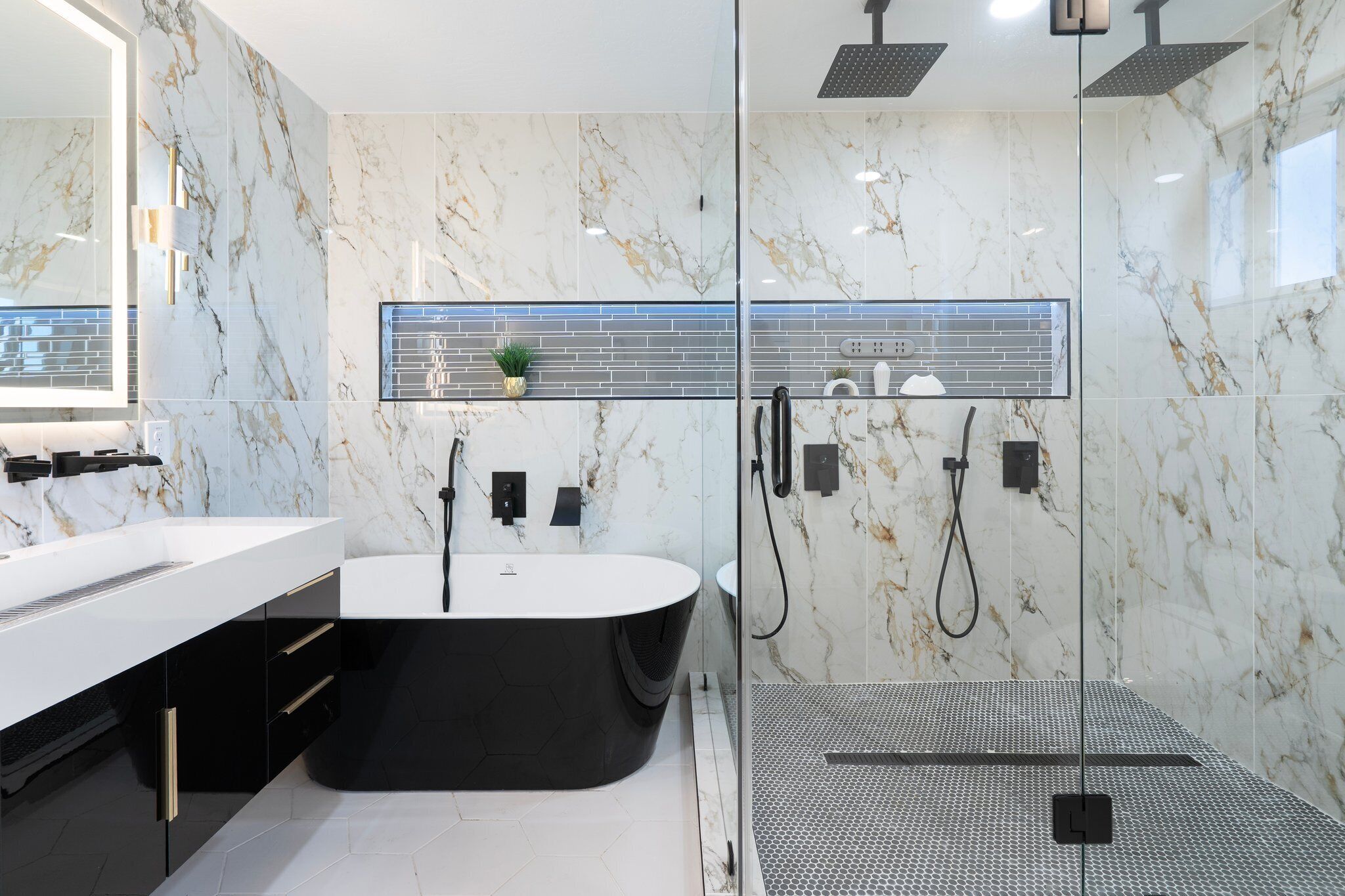 Un baño moderno con una bañera independiente, ducha con mampara de vidrio y un espejo grande.