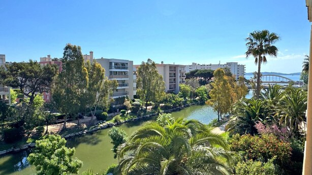 A riverside view with a bridge in the distance, surrounded by greenery and buildings. - Apartment for 6 people - Swimming pool - Air conditioning - WiFi - Sainte Maxime (STE MAXIME)