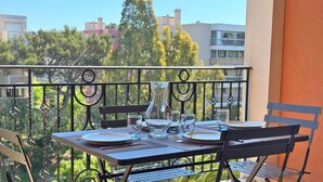 A balcony with a table set for two, featuring a clear glass pitcher, plates, and cutlery. - Apartment for 6 people - Swimming pool - Air conditioning - WiFi - Sainte Maxime (STE MAXIME)