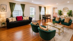 A modern living room with a sofa, chairs, a coffee table, and a foosball table. - Stay Near Beach, Sleep 12, Grill, Pool Table, Family & Event Open (West Palm Beach)