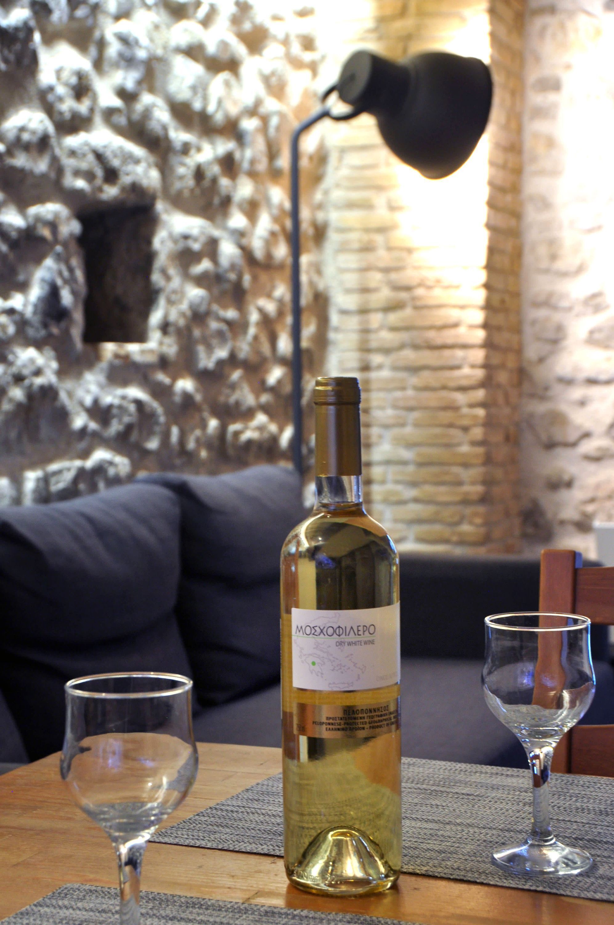 A bottle of wine on a table with two glasses.