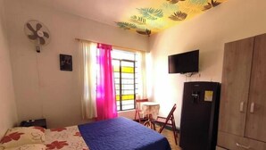 A bedroom with a bed, a desk, a chair, a TV, and a wardrobe. - Colorful awakening! apartment-studio (Cali)