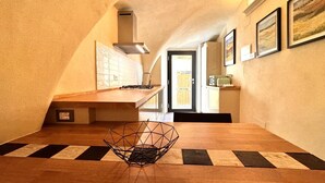 A modern kitchen with a wooden countertop, a geometric black bowl, and a view of the outside through a glass door. - Stalloregis 19 - near the Duomo (Siena)